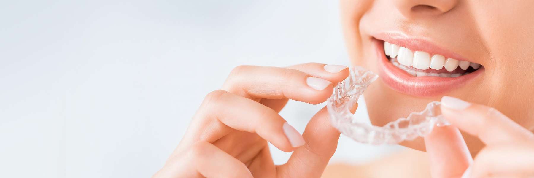 A patient holding Invisalign aligners in Jonesboro, AR