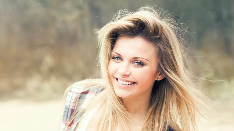 Lady smiling after getting Invisalign aligners from Dental Solutions