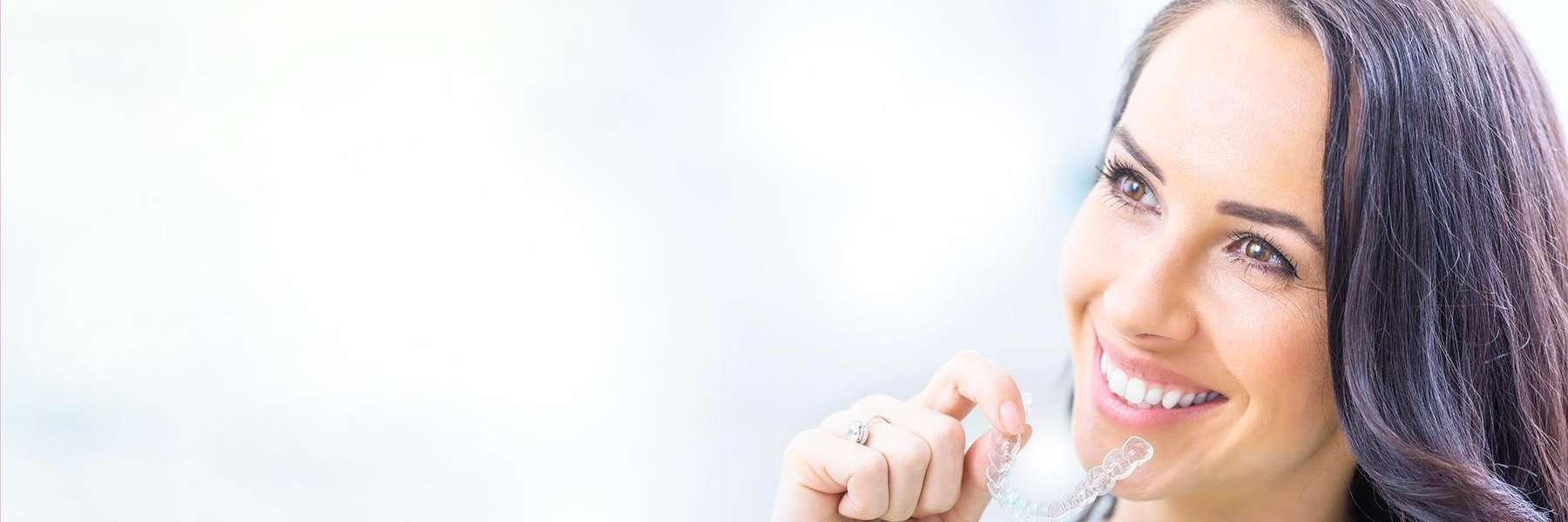 A lady holding Invisalign clear aligners in Jonesboro, AR